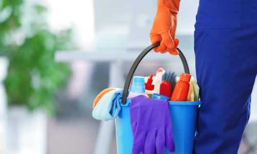 holding cleaning products and tools on bucket, close up
